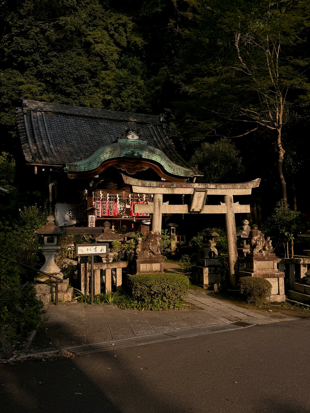 伝統的な日本の神社の建物を案内する石造りの鳥居。