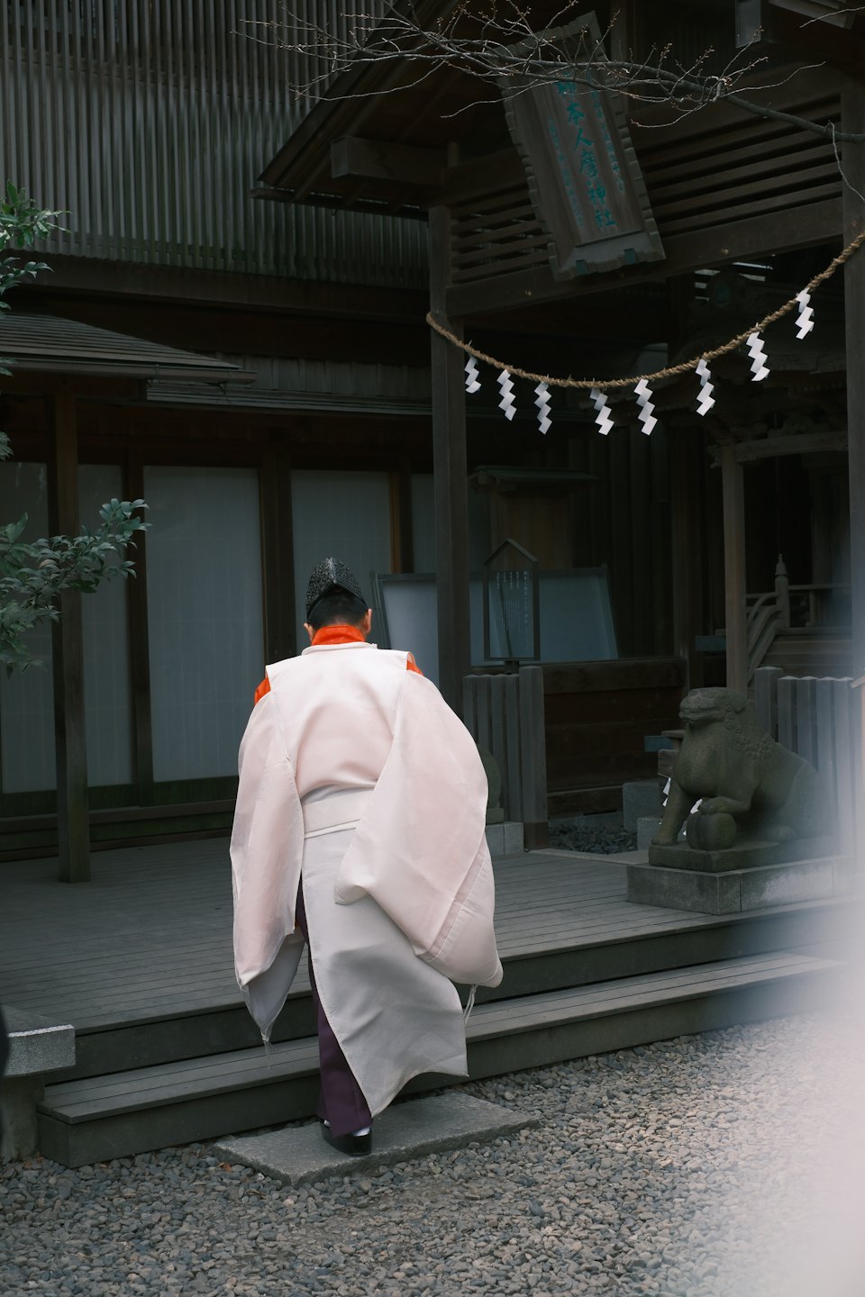 着物姿の人が日本の神社の建物を目指して歩いている。