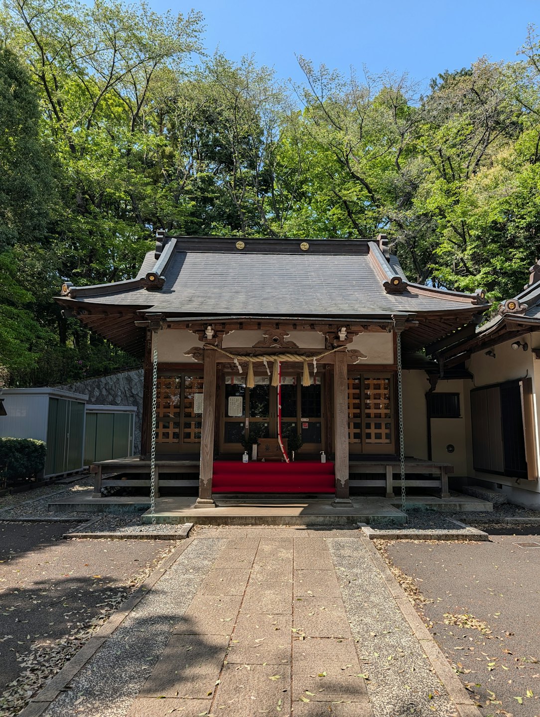 緑豊かな木々に囲まれた、伝統的な木造の日本の神社。